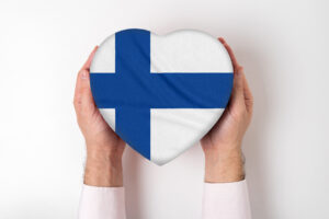 Flag of Finland on a heart shaped box in a male hands. White background